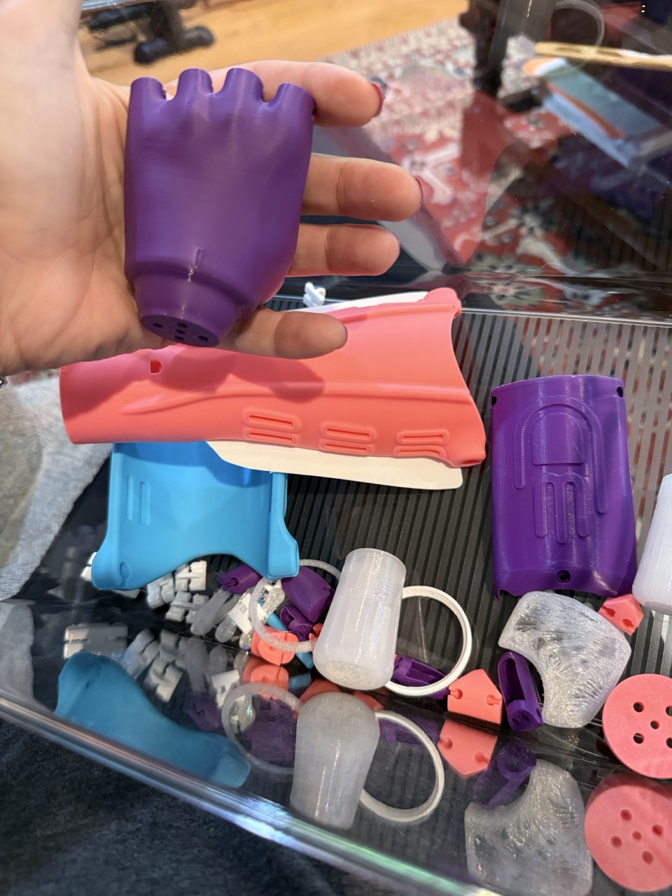 Holding the purple palm piece over a tray of sorted components